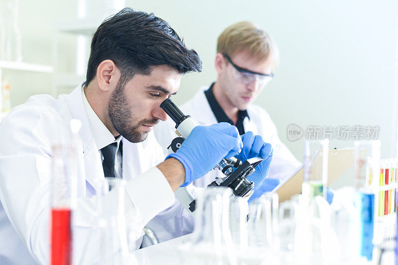 科学家研究团队一起在现代实验室进行实验和观察显微镜/科学家在实验室生物化学、遗传学、法医学、微生物学和试管
